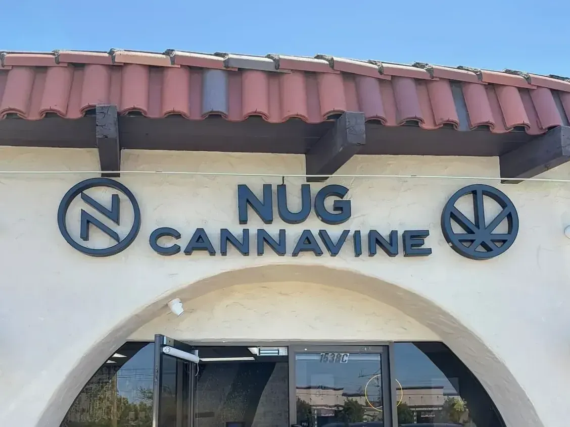 Nug Cannavine storefront with red tile roof and arched entrance